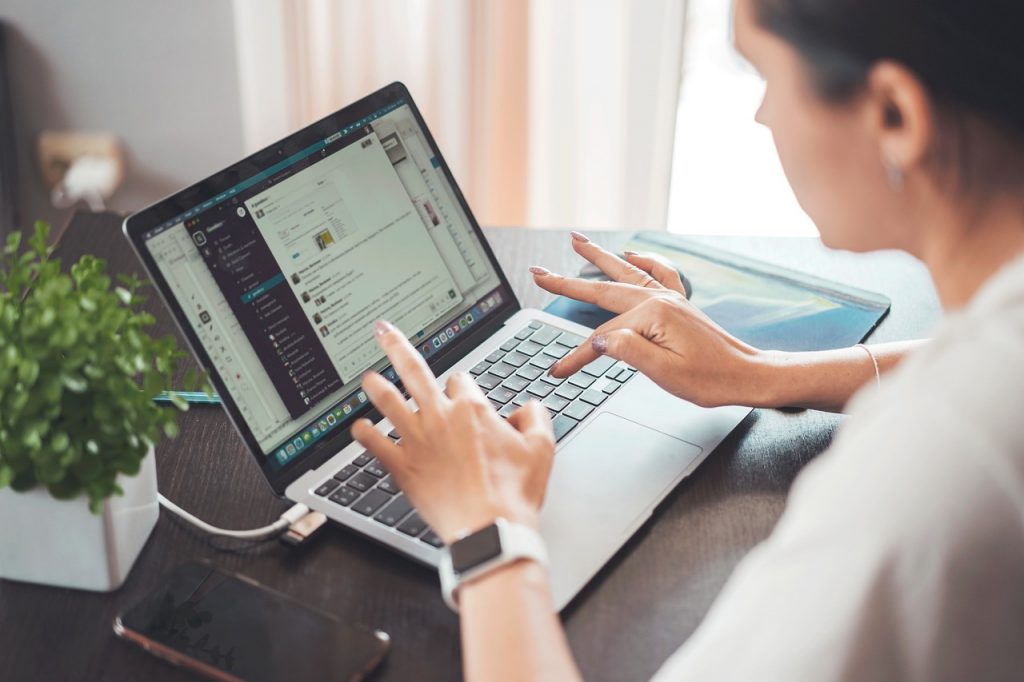 Closeup of woman working on a laptop on table at home.