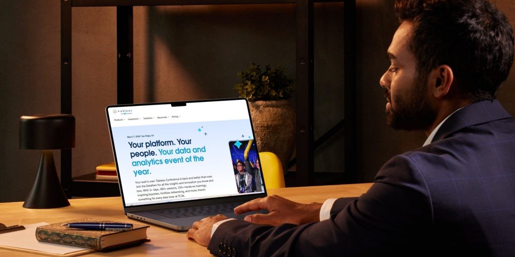 Closeup of businessman at desk working on Tableau platform on his laptop.