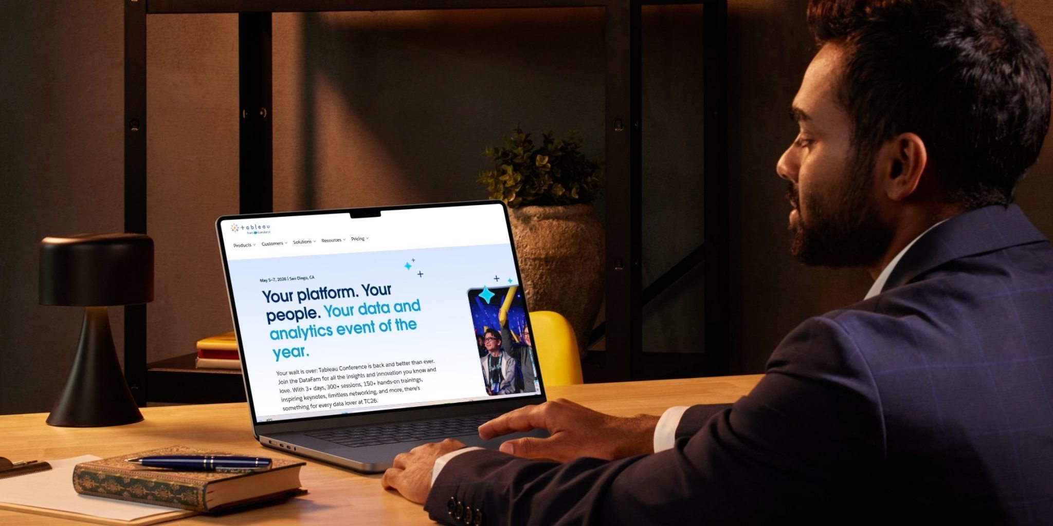 Closeup of businessman at desk working on Tableau platform on his laptop.