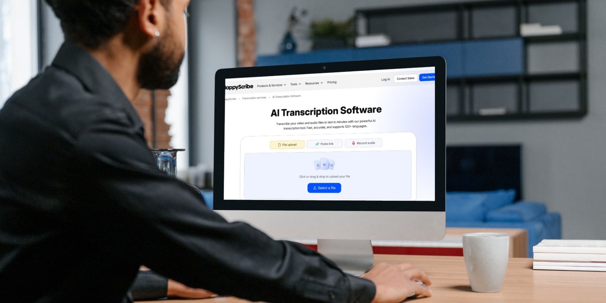 Closeup of a person sitting at a laptop with a screen that says "AI Transcription Software"