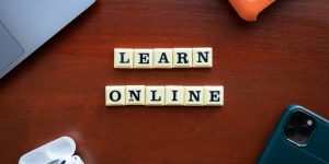 Closeup of square letters on desk that spell out LEARN ONLINE.
