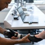 A doctor helping to fit a patient with a prosthetic arm.