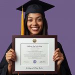 Graduate in a cap and gown against a purple background holding a College of Fine Arts diploma frame with white matting and black embossing.