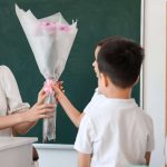 students handing teacher a gift of flowers