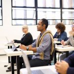 Classroom with teacher in front of class and adult education students.