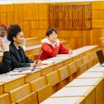 Professor speaking to young adults in a lecture hall.