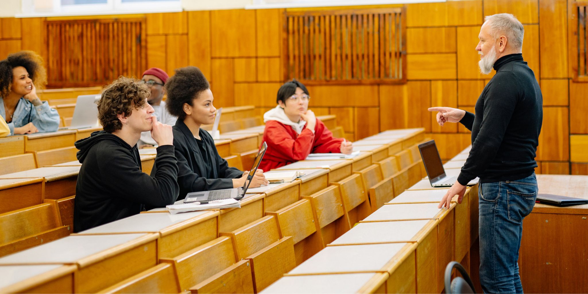 Professor speaking to young adults in a lecture hall.