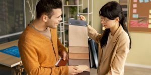 Person holding fabric samples for the customer with color swatches of mats trying to match the color.