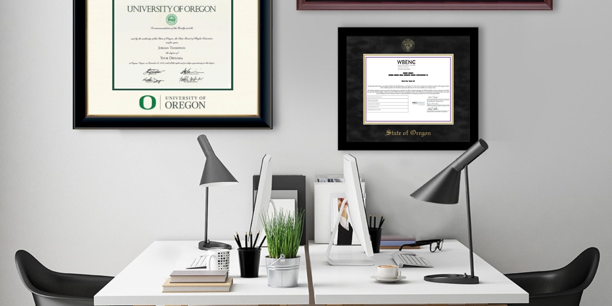Home office with white desks and black chairs with University of Oregon diploma frame and State of Oregon certificate frame on wall.
