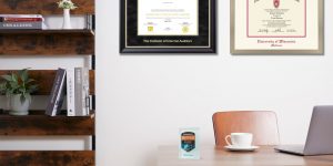 Office space featuring The Institute of Internal Auditors certificate frame and a University of Wisconsin Madison diploma frame on the wall and a Databricks digital badge on the desk next to a white coffee cup.