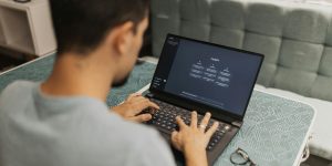 Person typing on a laptop that says "ChatGPT" on the screen.