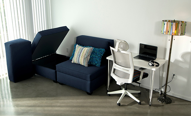 Sofa next to table with laptop