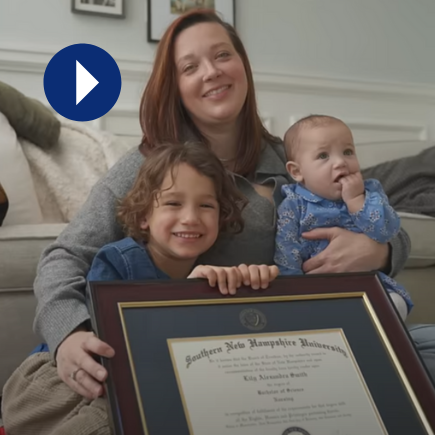 Woman sitting with two children, smiling with framed diploma in foreground, next to a play icon (video thumbnail)