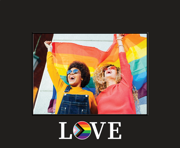 Framed photo of two smiling people holding a rainbow pride flag above the word ‘LOVE’ with a rainbow heart symbol.