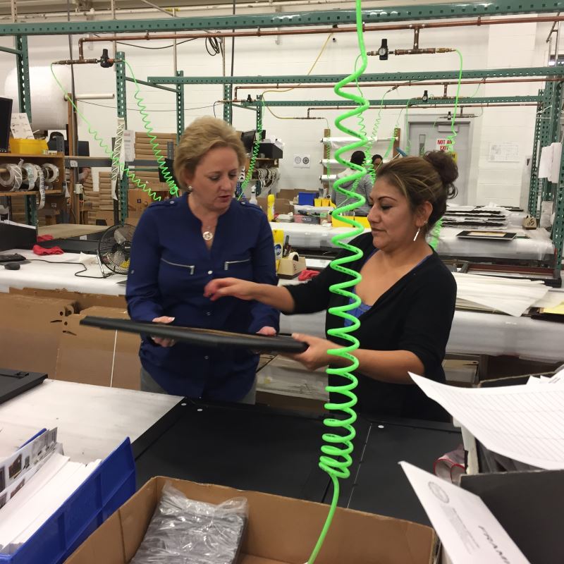 Lucie inspecting diploma frame in warehouse
