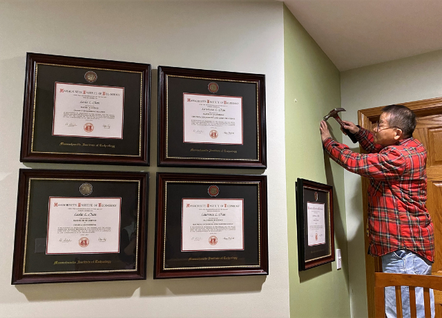 man hanging frames on wall