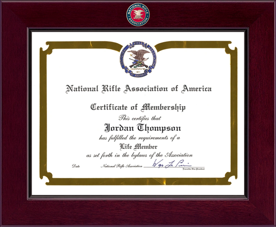 Framed National Rifle Association certificate of membership displayed in a cherry wood frame with an NRA emblem at the top.