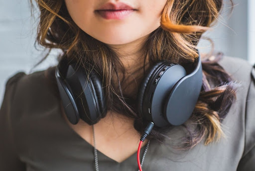 young woman with headphones around neck