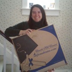 Smiling woman holding a Church Hill Classics diploma frame box