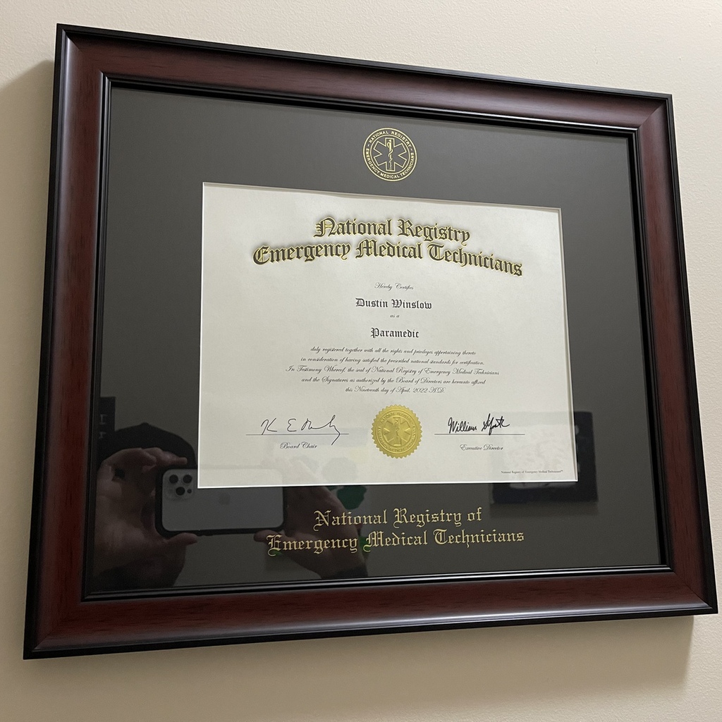 NREMT certificate frame hanging on the wall