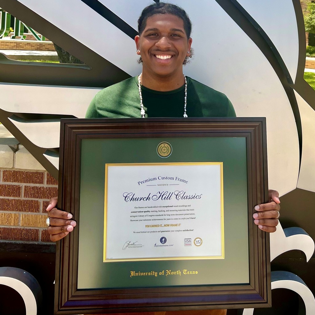 UNT student holding diploma frame