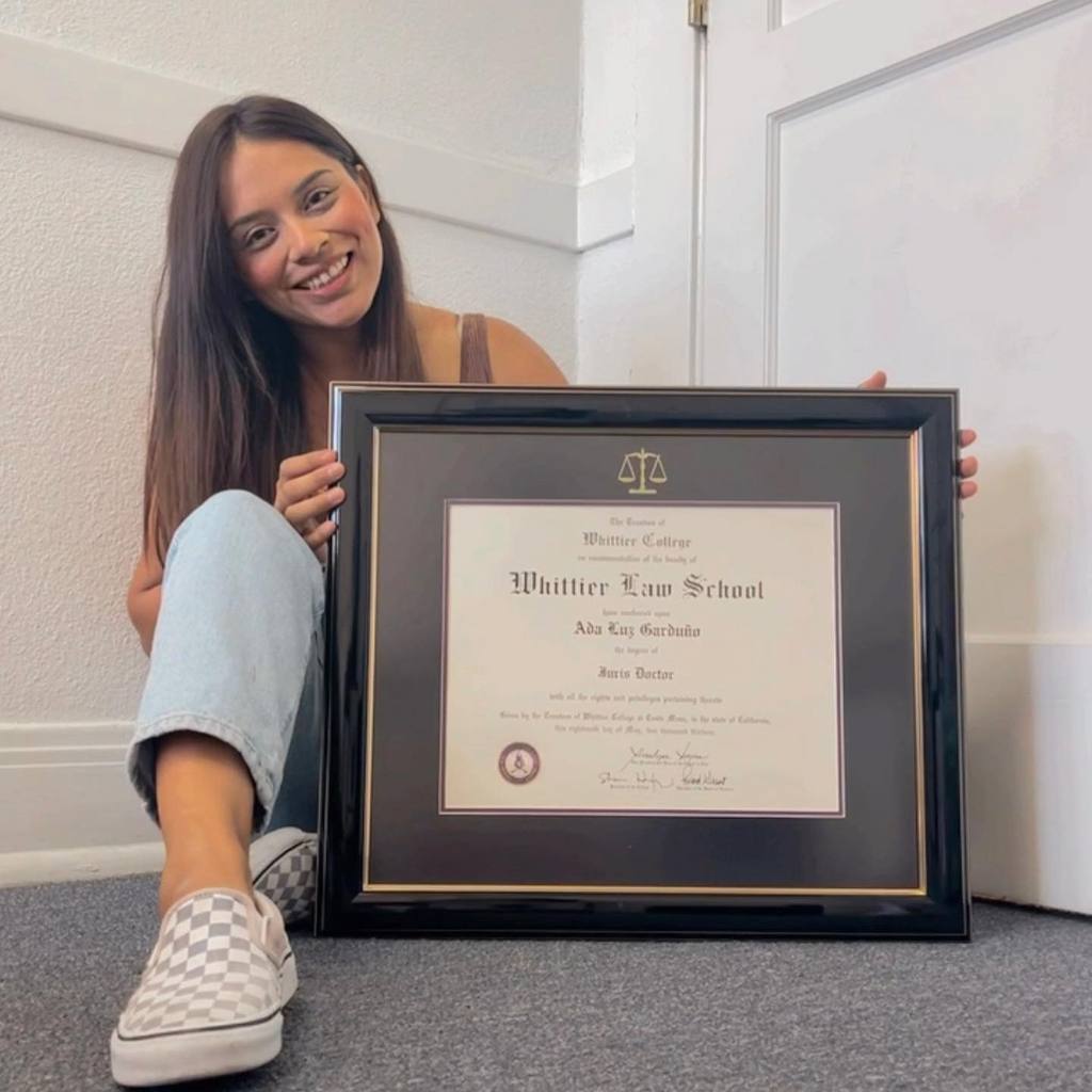 Happy Grad holding her custom Whittier Law School diploma frame