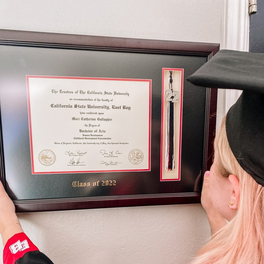 Grad hanging her Custom Class of 2022 Tassel Diploma Frame