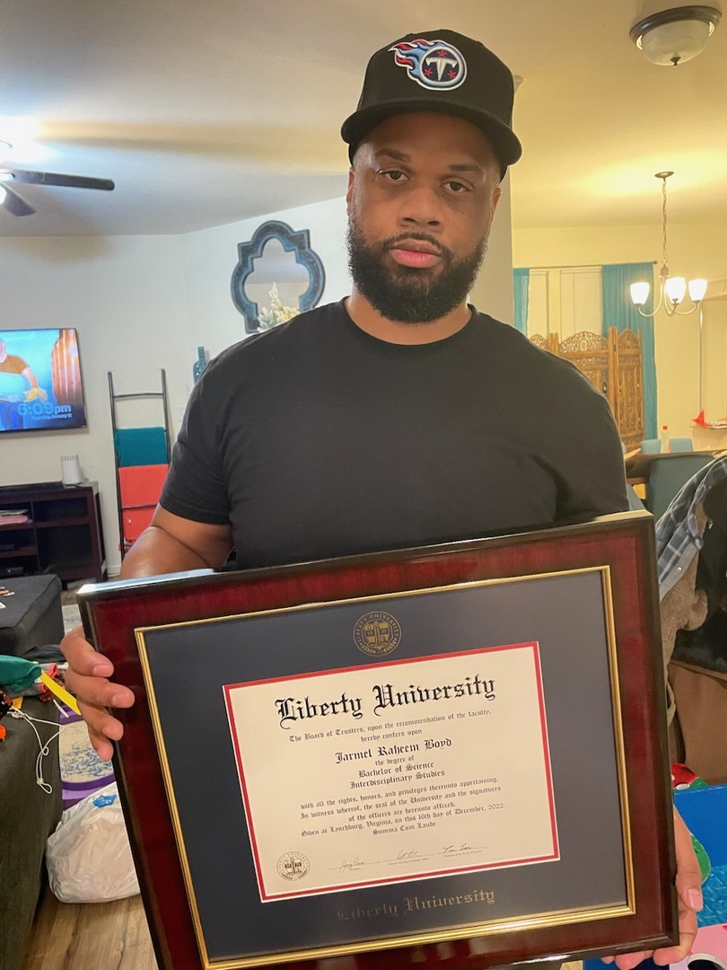 Grad holding his Embossed Liberty University diploma frame