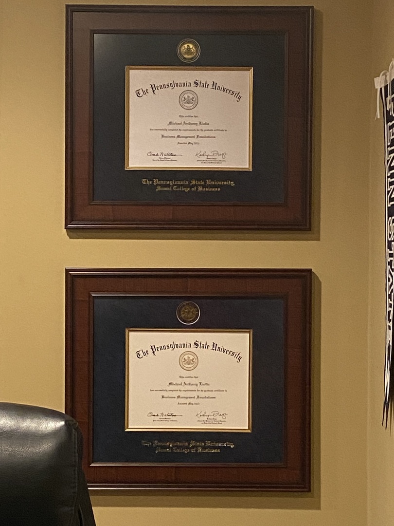Two Penn State business degree frames on wall