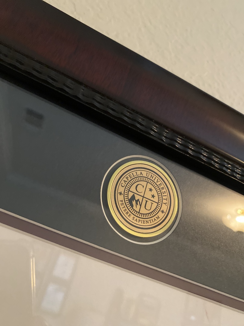 Closeup of Capella University school seal medallion on diploma frame