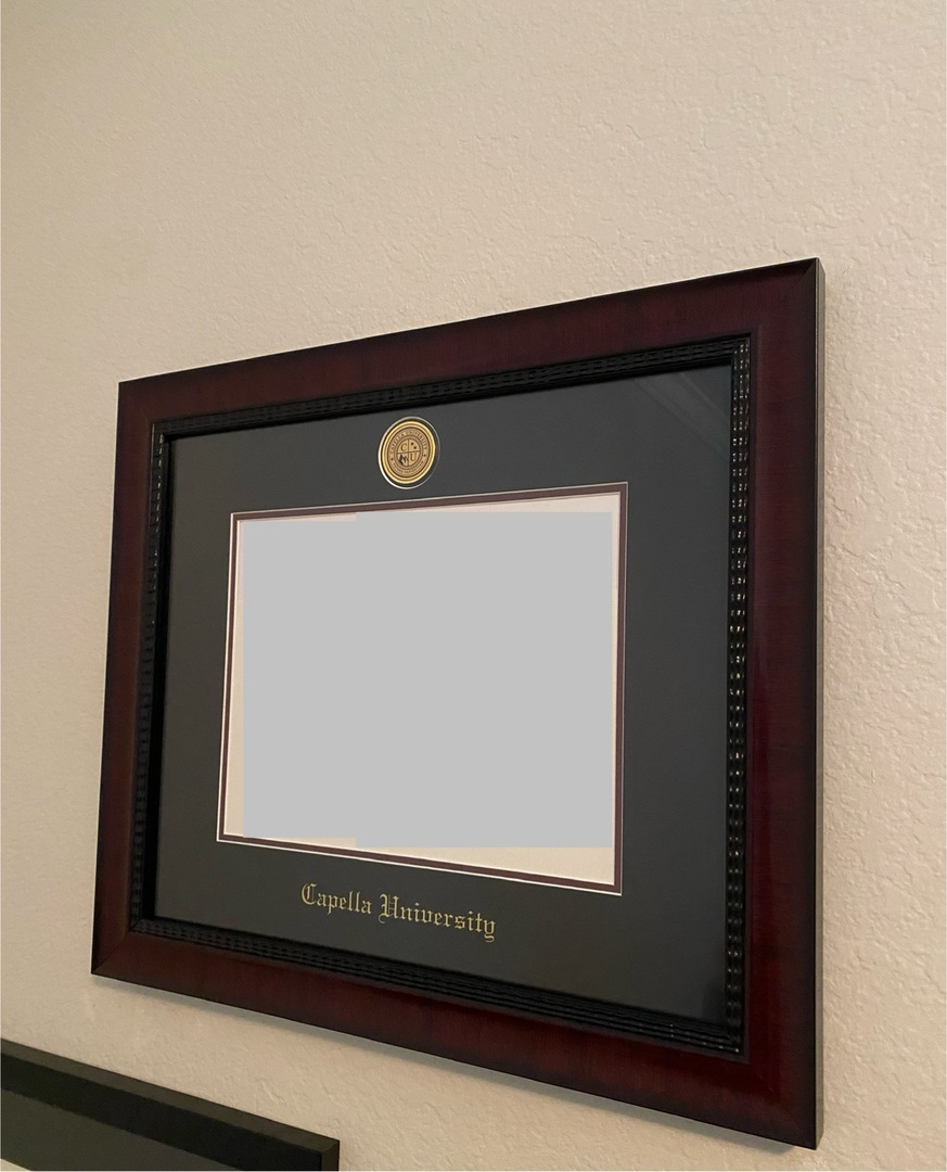 Capella University diploma frame on beige wall