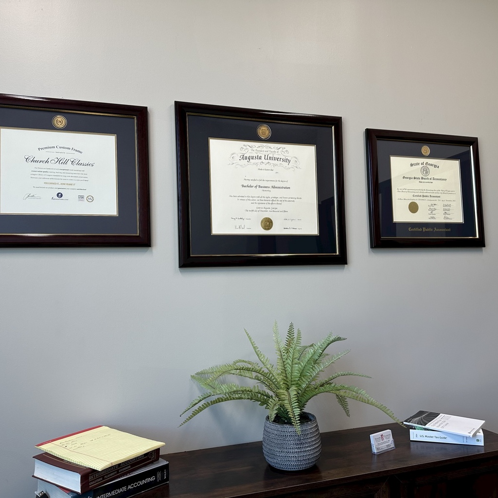 three custom certificate frames on office wall