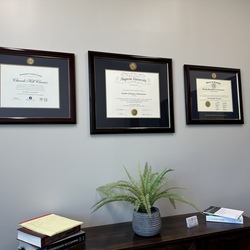 three custom certificate frames on office wall