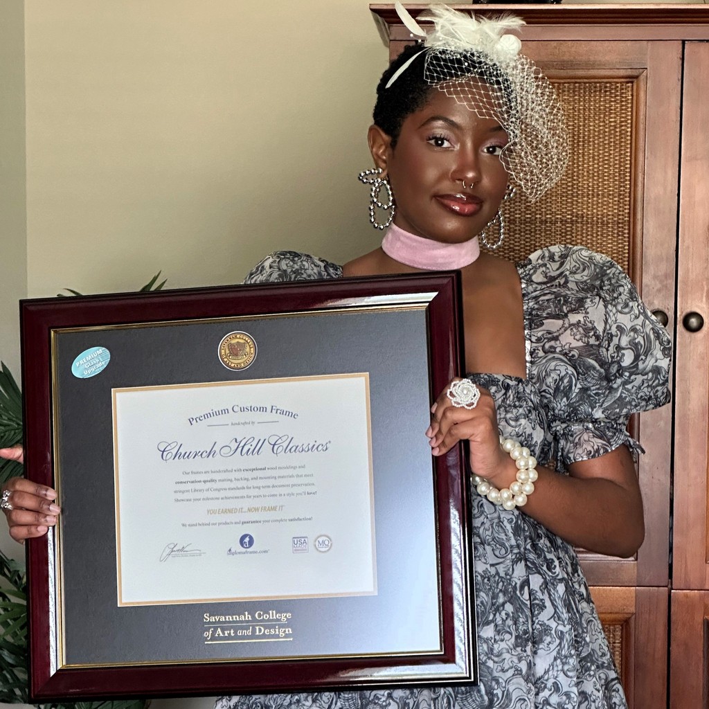 girl with veil headband holding SCAD diploma frame