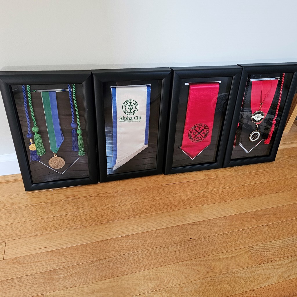 four college graduation stole frames leaning against wall