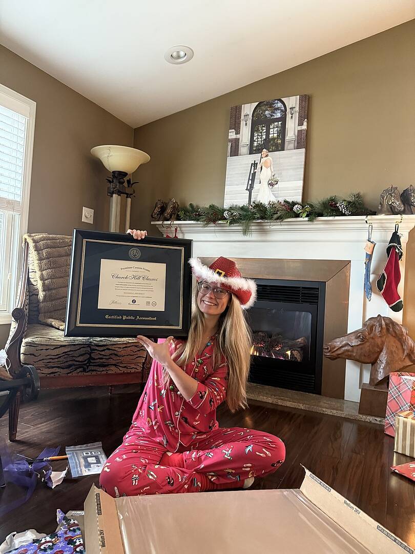woman in christmas pjs and santa cowboy hat holding certified public accountant frame