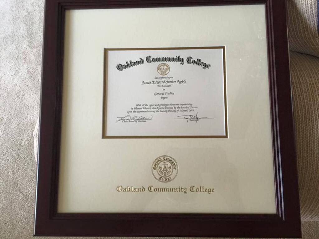 closeup of oakland community college diploma frame with white mat