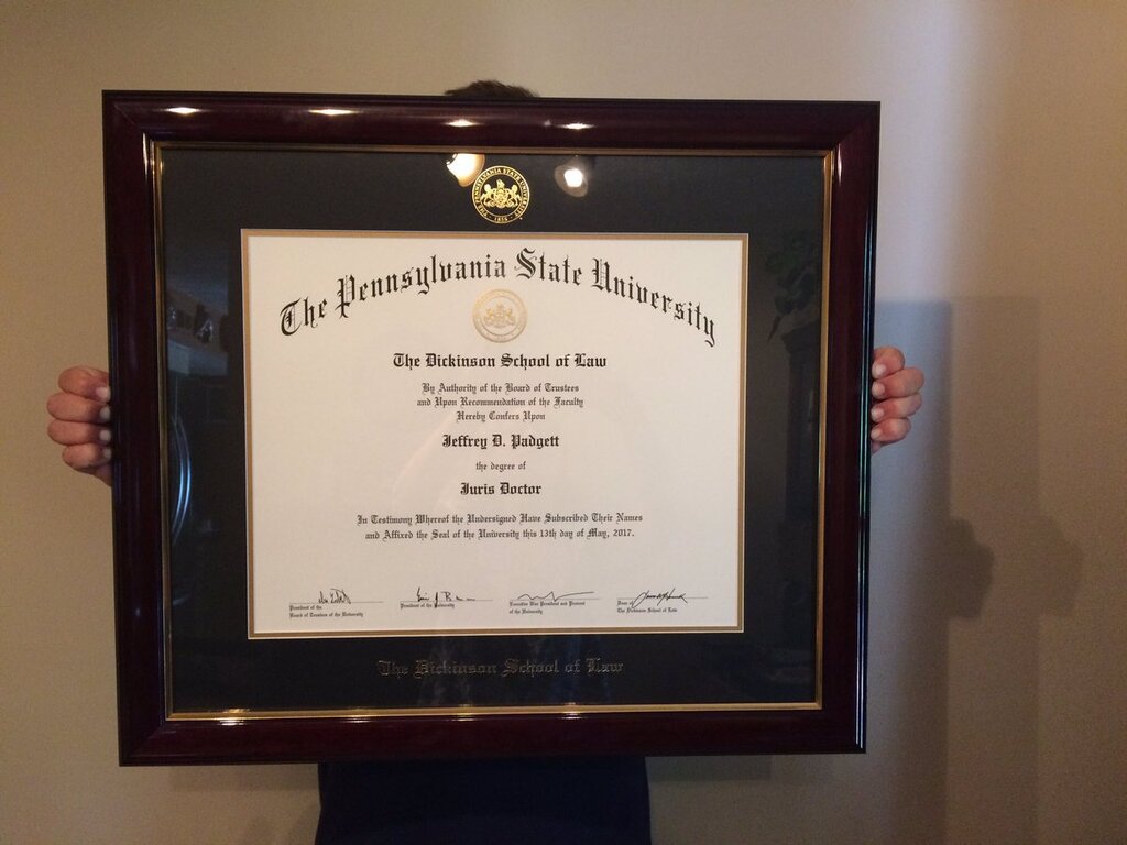 hands holding penn state law degree frame