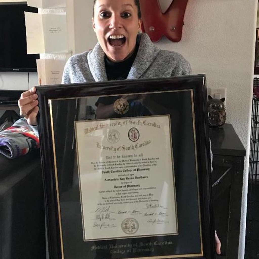 smiling woman holding a University of South Carolina diploma frame