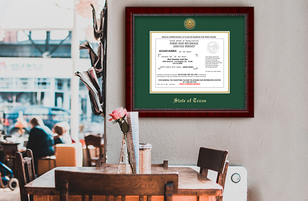 State of Texas document frame on a wall above a table in a restaurant