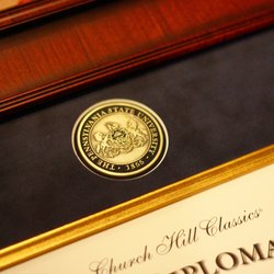 close up engraved medallion on a Pennsylvania State University diploma frame