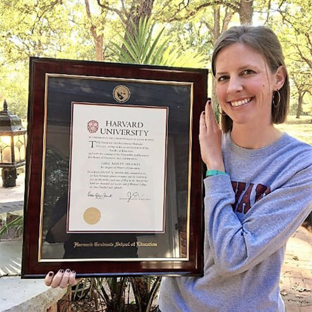 Woman holding Harvard Graduate School of Education diploma frame outdoors