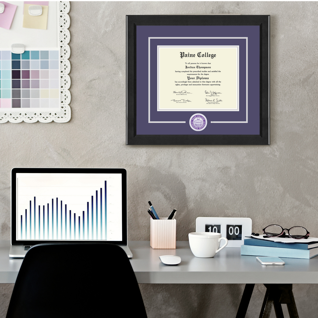 a home office space with a Paine College diploma frame hung above a desk