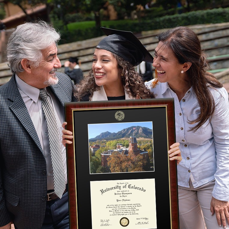 two parents smiling at their daughter graduate holding a custom University of Colorado diploma frame
