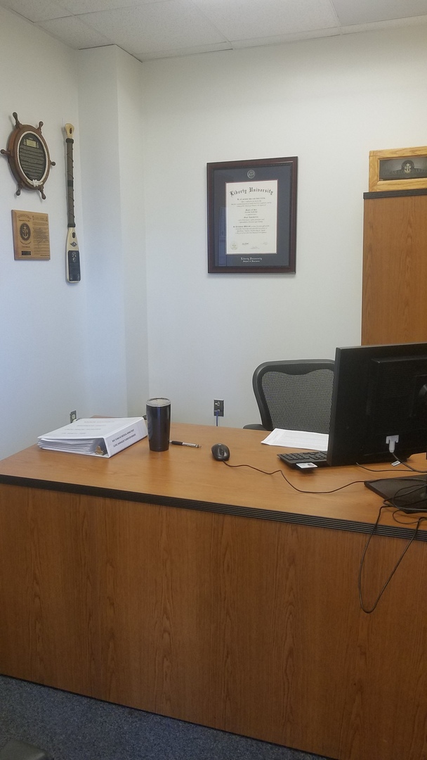Liberty University diploma frame hanging on an office wall behind a desk
