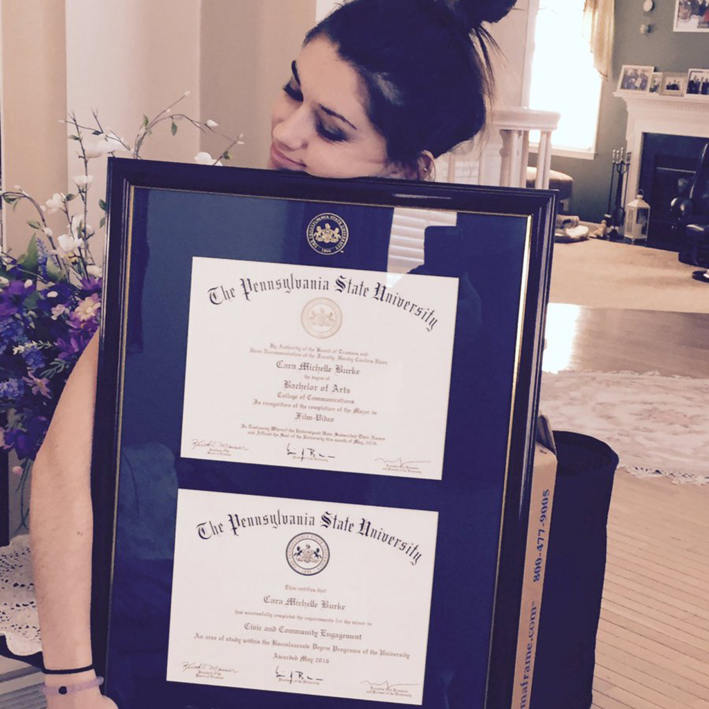 Grad hugging Penn State double diploma frame