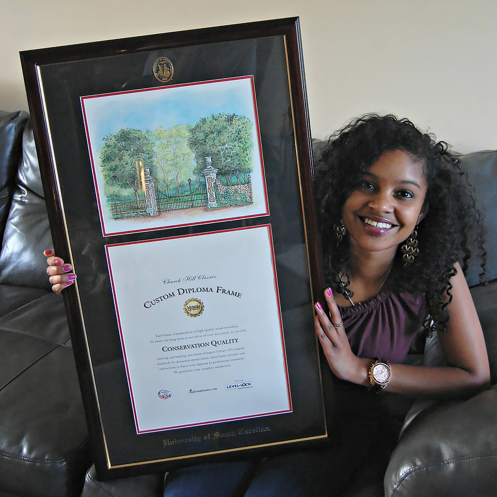 Grad on couch holding USC diploma frame