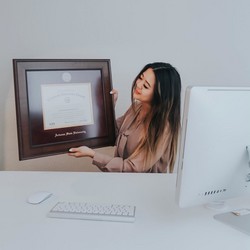 Woman at her desk holding a premium ASU diploma frame